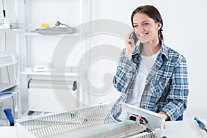 female worker making call in distribution warehouse