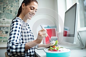 Female Worker In Office Having Healthy Chicken Salad Lunch At Desk