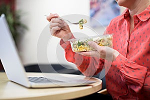 Female Worker In Office Having Healthy Pasta Lunch At Desk