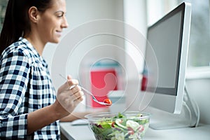 Female Worker In Office Having Healthy Salad Lunch At Desk