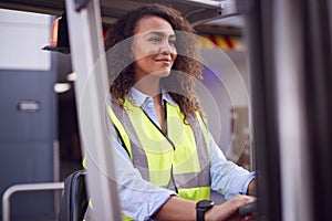 Female Worker Operating Fork Lift Truck At Freight Haulage Business