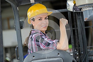 Female worker operating forklift truck in shipping yard