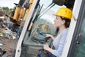 Female worker operating forklift truck in shipping yard