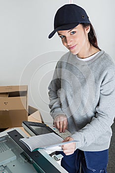 Female worker photocopying book