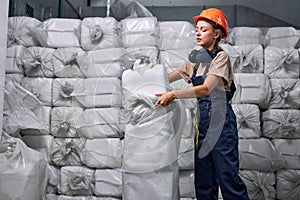 Female worker in protective uniform working in pesticides production factory