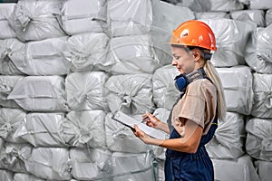 Female worker in protective workwear working in pesticides production factory