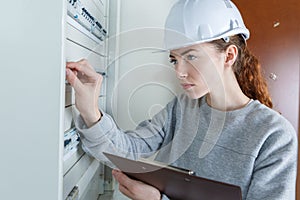 Female worker pushing lever in fuse box