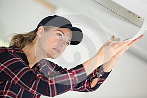 female worker repairing air conditioner