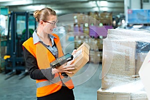 Female worker scans package in warehouse of forwarding