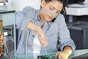 Female worker screwing computer piece