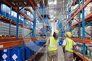 Female worker showing something to male worker in warehouse