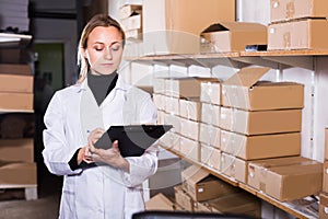 Female worker transporting cart cardboard cases