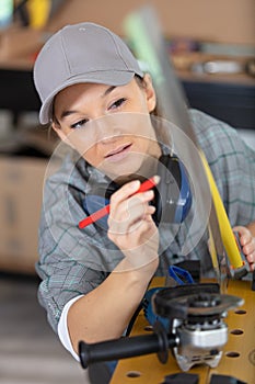 female worker using angle grinder in workshop