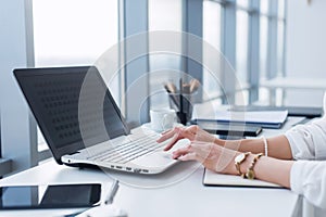 Female worker using laptop in office, working with new project. Woman blogging at home as a freelancer. photo