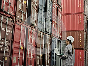 Female worker wearing safety helmet and working with container