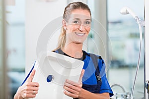 Female worker at work in a sanitary shop with high-quality ceramic fixtures