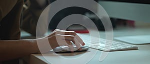 Female worker working with computer device on white office desk with camera and other supplies