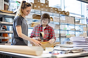 Female Workers Taping Cardboard Boxes