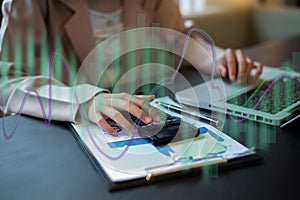 Female working on desk office with using a calculator to calculate tax