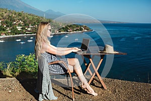 Female working with her laptop near the sea