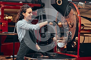 Female working with rosting coffee machine. Front view