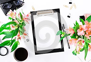 Female workspace with clipboard, office accessories, coffee and