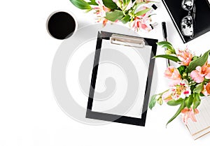 Female workspace with clipboard, office accessories, coffee and