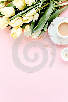 Female workspace with tulip flowers bouquet, golden accessories, diary, on pink background. Flat lay women's office desk