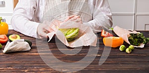 Female wrapping cheese into beeswax wraps at the kitchen