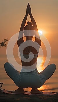 Female yoga practitioner gracefully holds tree pose at beach during stunning sunset