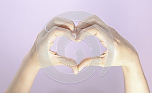 femalehand making a heart shape on  beautiful woman's hand with copy space, valentine's day love conce