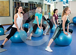Females with fitness ball at gym.