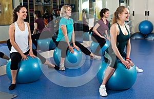 Females with fitness ball at gym.