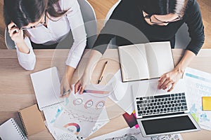 Females with paperwork and blank laptop