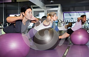 Females working out with aerobic ball in modern gym