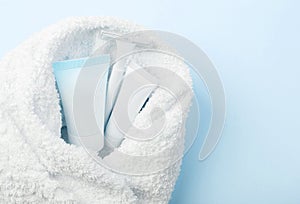 Femine body shaving set covered in towel on blue, powder background. photo