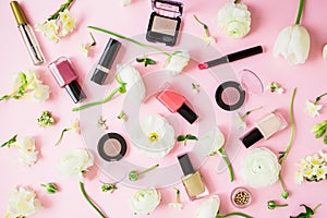 Feminine cosmetics and white flowers on pink background. Flat lay, top view