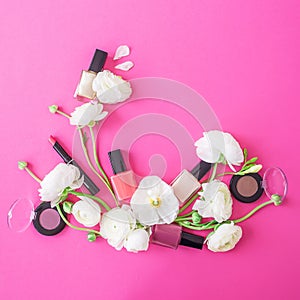 Feminine desk with woman cosmetics and white flowers on pink background. Flat lay, top view. Beauty background