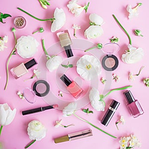 Feminine desk with woman cosmetics and white flowers on pink background. Flat lay, top view. Beauty concept for blog