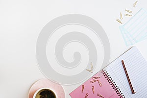 Feminine flat lay with pink notebook with empty lined pages, metal pen, stickers, paper clips and green tea