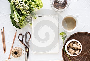 Feminine flatlay with flowers and ccoffee