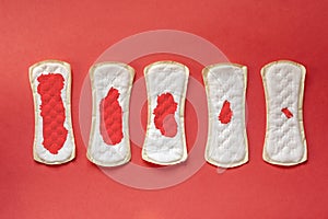 Feminine hygiene pads with blood during period days on red