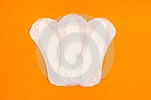 Feminine hygiene panty liner for menstruation. Menstrual cycle, pad. Orange  background.