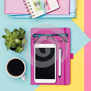 Office Desk Working Space Flat Lay. Top view photo of workspace with smartphone, coffee, notepad and woman fashion magazines. photo