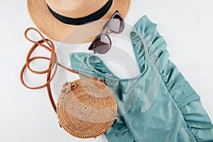 Feminine summer travel fashion concept. Swimsuit, hat, bag, sunglasses on white background, flat lay