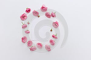 Feminine vertical birthday mock-up scene. Blank paper greeting pink roses on white table background. Light. Flat lay