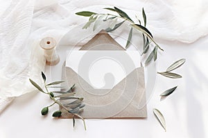 Feminine wedding stationery, desktop mock-up scene. Blank horizontal greeting card with craft envelope, silk ribbon and