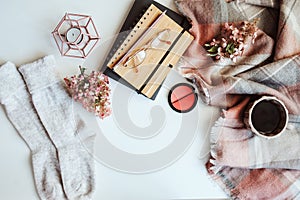 feminine winter table, woman fashion clothes and make up, sketch book and coffee