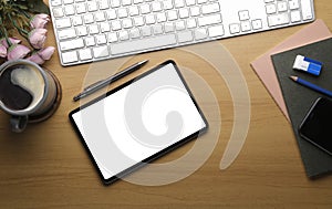 Feminine workplace with digital tablet, and coffee cup on wood background