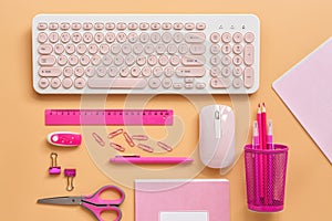 Feminine workspace with a computer and stationery to pink color on a pastel background. Flat lay office table desk frame